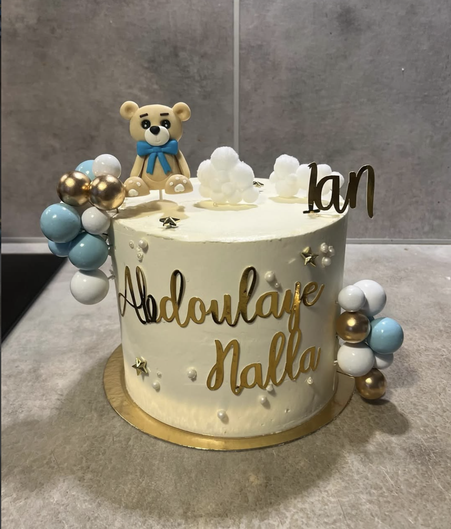 Gâteau anniversaire ourson bleu | Taasty Cakes Gâteau anniversaire ourson bleu — Un gâteau d’anniversaire tendre décoré d’un ourson, de ballons bleu ciel et de détails dorés, personnalisable avec un pr | Taasty Cakes