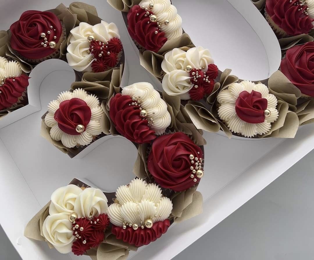 Cupcakes fleuris rouge et blanc | Taasty Cakes Cupcakes fleuris rouge et blanc — Une boîte de cupcakes élégants aux crèmes pochées rouge bordeaux et ivoire, décorés de perles dorées pour une présentati | Taasty Cakes