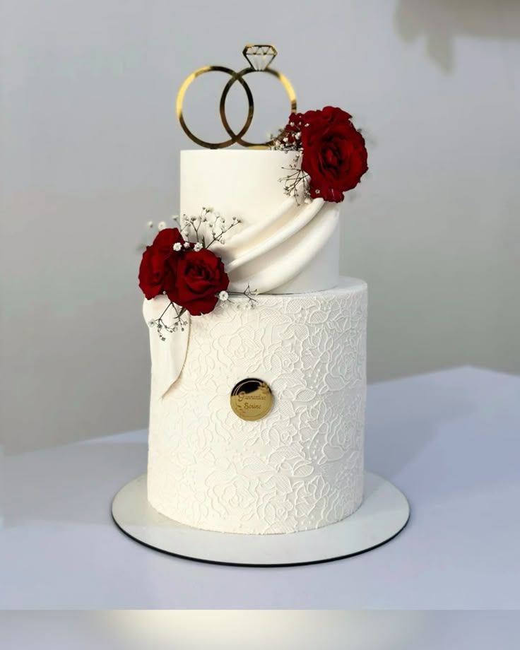 Gâteau de mariage aux roses rouges | Taasty Cakes Gâteau de mariage aux roses rouges — Une élégante pièce montée de mariage aux finitions blanches texturées, ornée de roses rouges et d’un topper raffiné. | Taasty Cakes