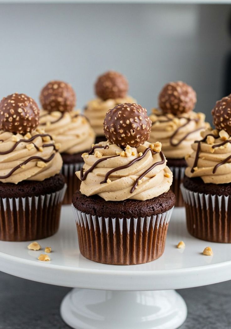 Cupcakes Ferrero noisette | Taasty Cakes Cupcakes Ferrero noisette — Des cupcakes au chocolat garnis d’une crème pralinée et décorés de noisettes croquantes, de chocolat fondu et d’une bouc | Taasty Cakes